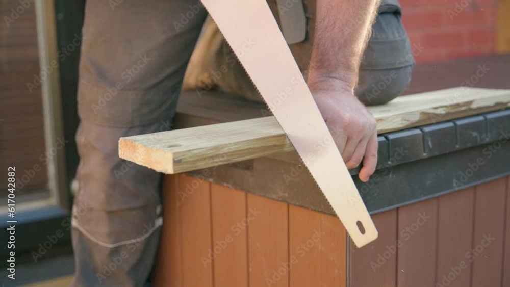 a man builder cutting timber with hand saw a man builder cutting timber with hand saw