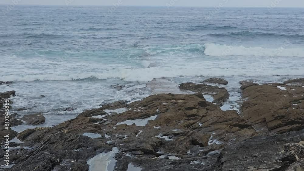 the waves crashing against rocks on the shore the waves crashing against rocks on the shore
