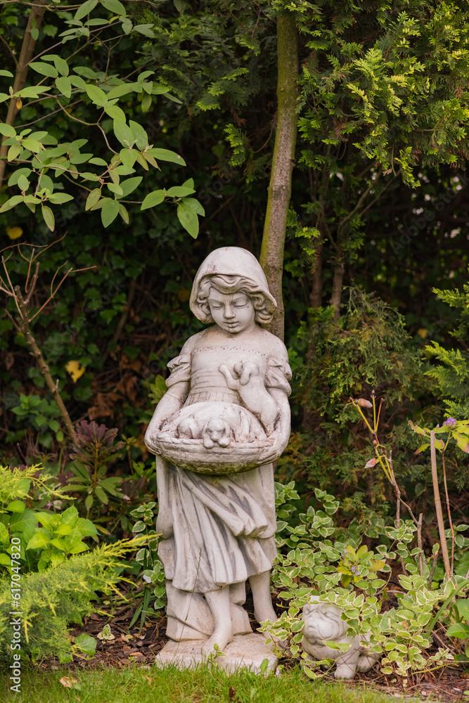 beautiful statue of a child with bunnies in a green garden beautiful statue of a child with bunnies in a green garden