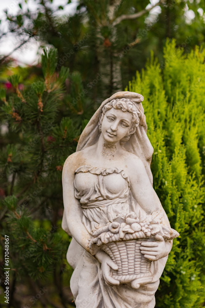 beautiful statue of a girl in a green garden