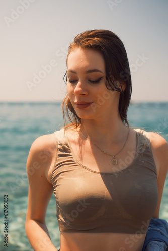 Portrait of a girl in wet clothes. Her gaze is downcast. Eyes closed