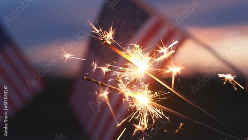 Fireworks sparklers fourth of July  Happy USA Independence Day Holiday  Celebration. Hands Holding Sparklers Fireworks with USA American Flag at sunset outdoor background. Concept 4th of July  Freedom