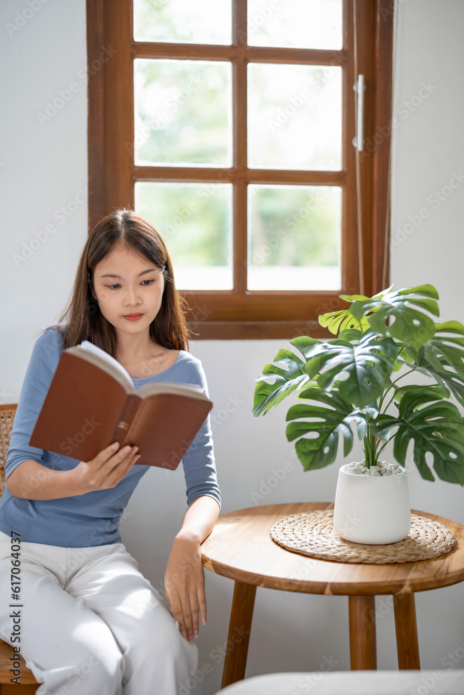 .Young asian woman reading a book at home, girl hold book Education school university college concept.concept. .Young asian woman reading a book at home, girl hold book Education school university college concept.concept.