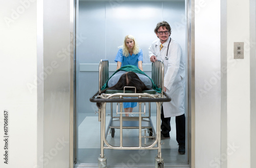 Young caucasian nurse pushing the patient bed out of the elevator to the emergency room of the hospital.