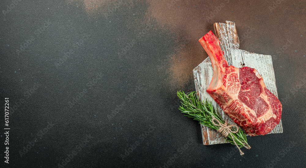 tomahawk steak. Raw beef meat on a wooden board. Long banner format. top view