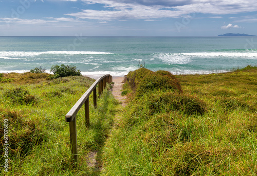 narrow beach path with wooden railing and ocean view