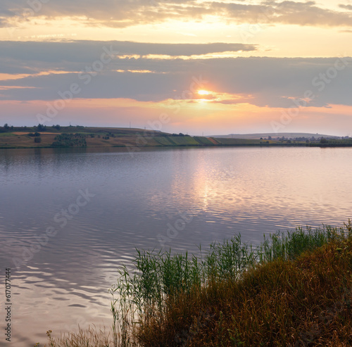Fototapeta Naklejka Na Ścianę i Meble -  Evening lake scenery with sun reflection on water surface.