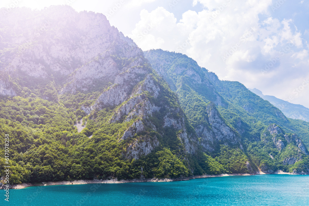 Landscape view of big lake between mountains at summer day. Travel background image with Piva lake in Montenegro