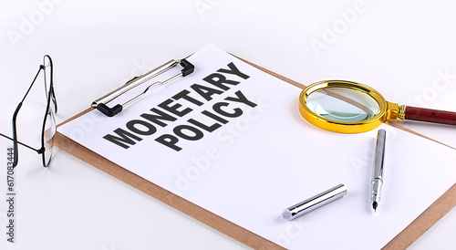 Obraz na plátně MONETARY POLICY text on clipboard on white background, business concept