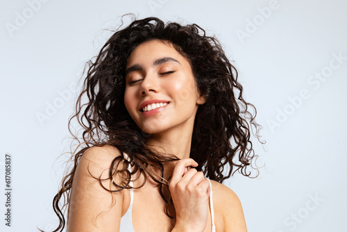 Fototapeta Happy young woman with natural beauty, and beautiful curly hair closed her eyes