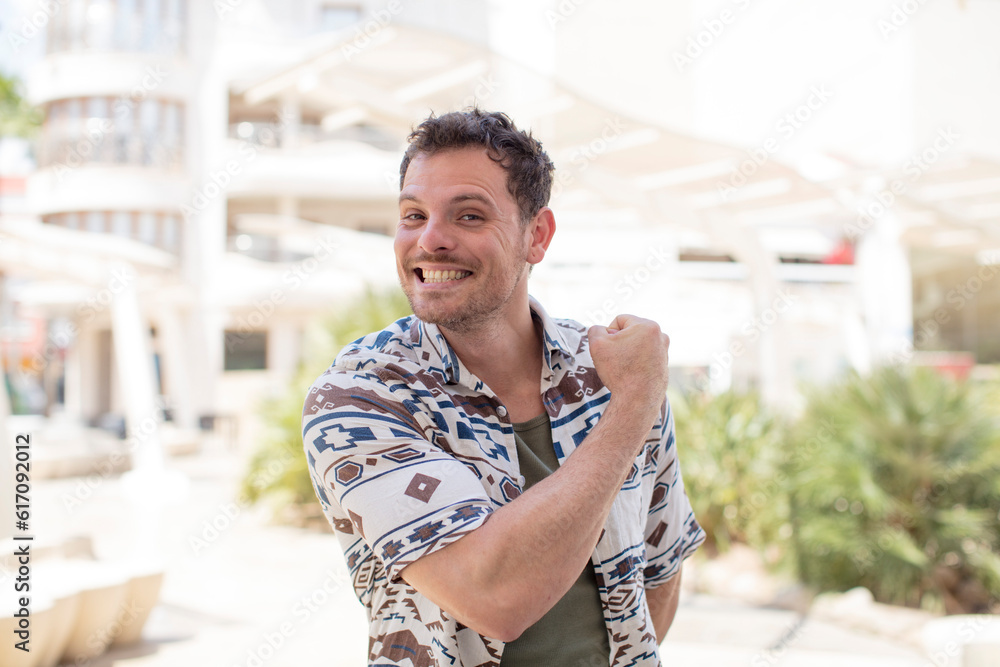 Fototapeta premium handsome man feeling happy, positive and successful, motivated when facing a challenge or celebrating good results