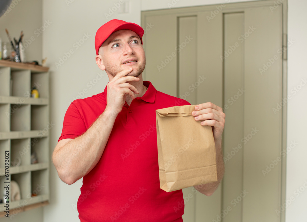 smiling with a happy, confident expression with hand on chin. delivery paper bag concept