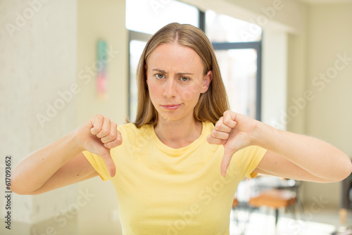 Wallpaper Mural pretty blond woman looking sad, disappointed or angry, showing thumbs down in disagreement, feeling frustrated Torontodigital.ca