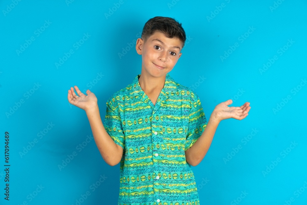 Careless attractive Little hispanic boy wearing green aztec shirt shrugging shoulders, oops. Careless attractive Little hispanic boy wearing green aztec shirt shrugging shoulders, oops.