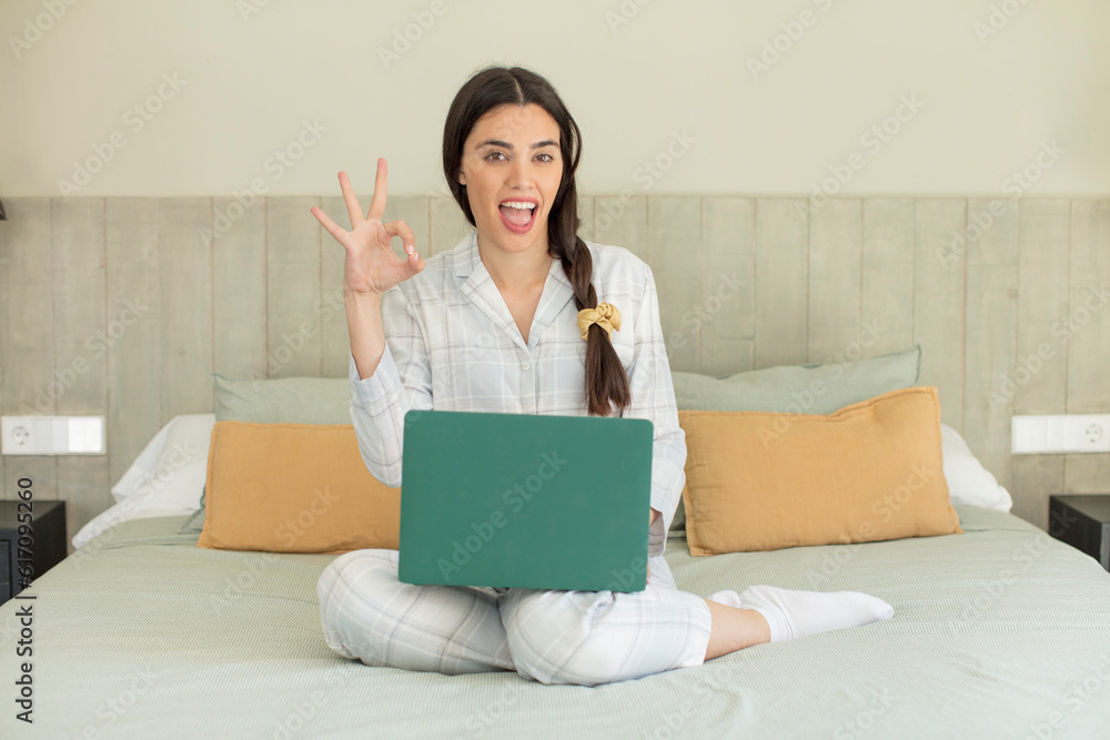 pretty young model feeling happy, showing approval with okay gesture. rest and nightwear concept