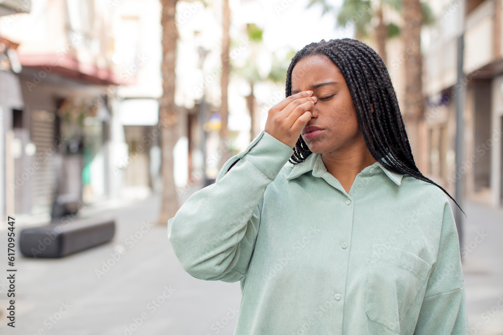 afro pretty black woman feeling stressed, unhappy and frustrated, touching forehead and suffering migraine of severe headache afro pretty black woman feeling stressed, unhappy and frustrated, touching forehead and suffering migraine of severe headache
