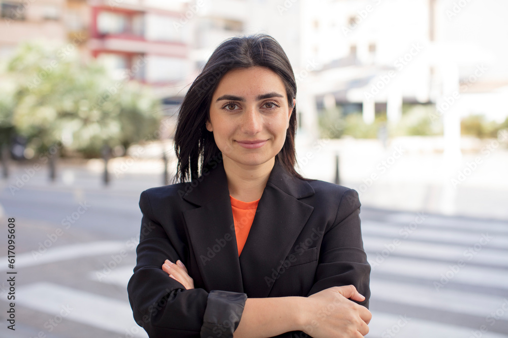 pretty woman smiling to camera with crossed arms and a happy, confident, satisfied expression, lateral view pretty woman smiling to camera with crossed arms and a happy, confident, satisfied expression, lateral view