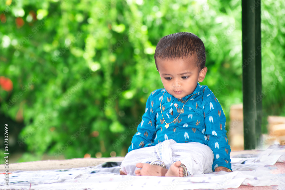Beautiful little baby, little baby with a happy face and background green. cute Indian baby