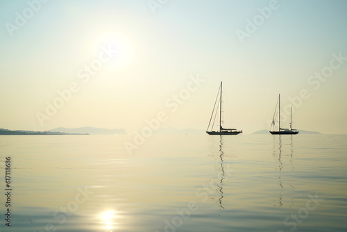 Sailing boats at anchor on the Aegean Sea in early morning light