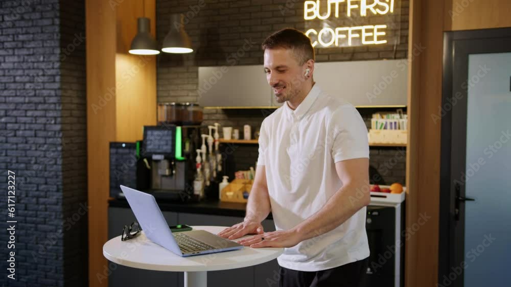 A young man during a video call with colleagues on the background of an office cafe A young man during a video call with colleagues on the background of an office cafe