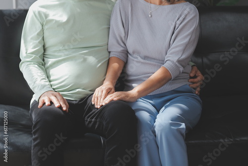 Embraced mature couple surfing the Internet on laptop at home