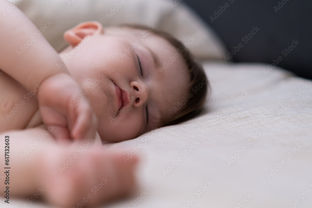 Cute chubby baby sleeping on soft bed with white sheet after breastfeeding innocent little boy with closed eyes taking nap in cozy nursery at home closeup Cute chubby baby sleeping on soft bed with white sheet after breastfeeding innocent little boy with closed eyes taking nap in cozy nursery at home closeup