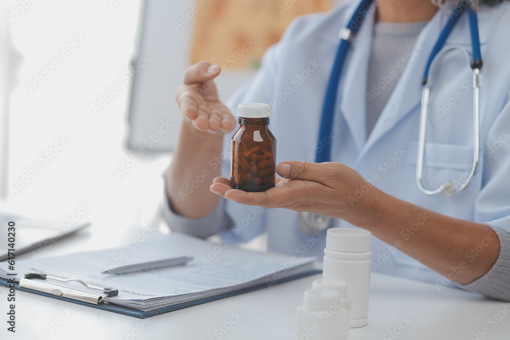 Mature Asian male doctor talking with his patient, explaining the procedure to old lady.