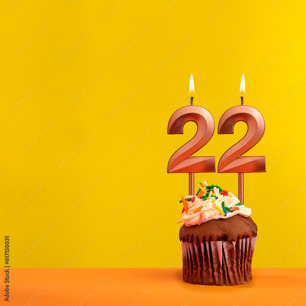 Candle with flame number 22 - Birthday card on yellow background