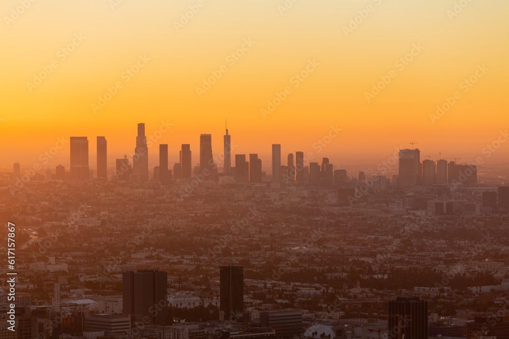 Smoggy orange sunrise cityscape view of Los Angeles and Hollywood from hilltop in the Santa Monica Mountains. Smoggy orange sunrise cityscape view of Los Angeles and Hollywood from hilltop in the Santa Monica Mountains.