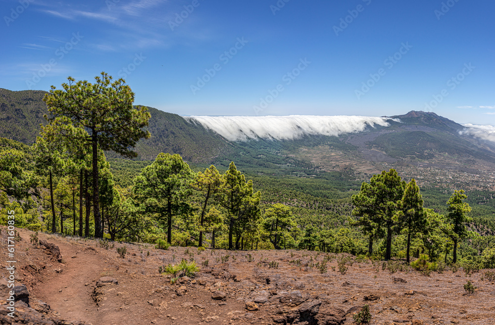 Clouds move over the mountain slope of Cumbre Nueva and flow into the valley like a waterfall, La Palma, Canary, Spain, Europe