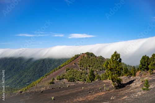 Clouds move over the mountain slope of Cumbre Nueva and flow into the valley like a waterfall, La Palma, Canary, Spain, Europe