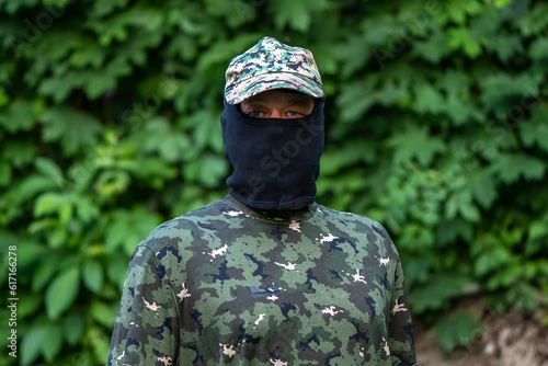 Portrait of a military mercenary in balaclava and military uniform on a blurry background. Concept: armed conflict, the seizure of territory, war in Ukraine. photo