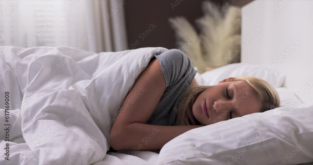 Woman sleeping. High angle view of beautiful young woman lying in bed and keeping eyes closed while covered with quilt. Woman sleeping. High angle view of beautiful young woman lying in bed and keeping eyes closed while covered with quilt.