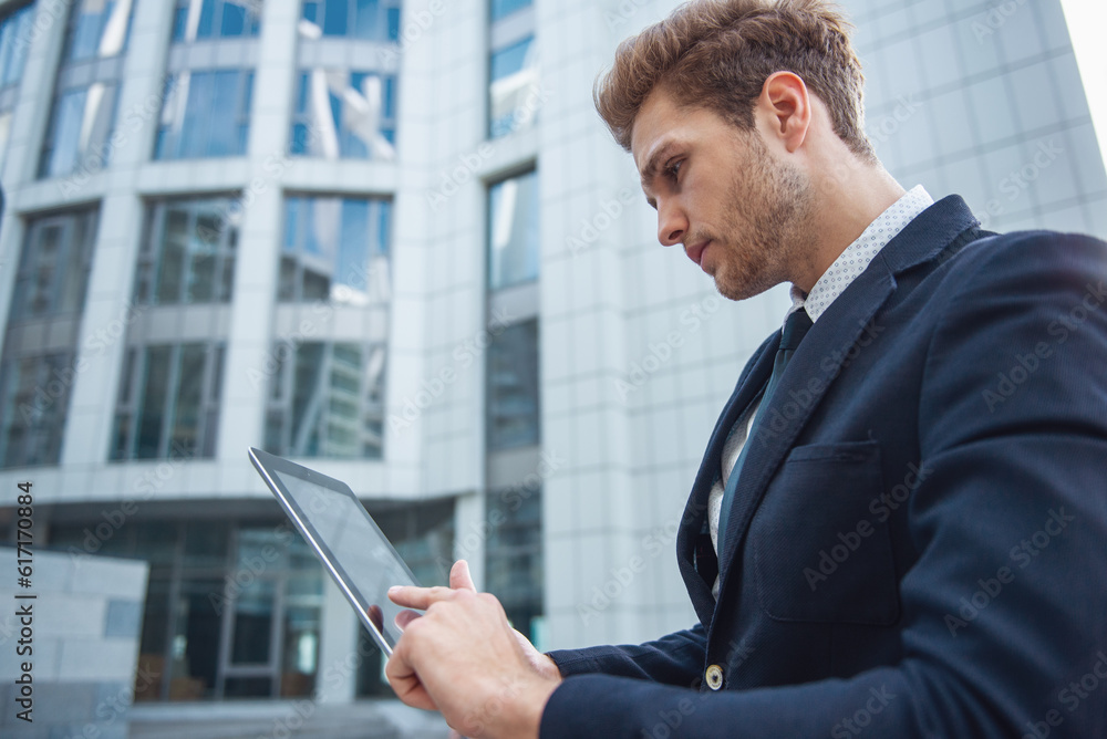 Attractive young businessman with gadget Attractive young businessman with gadget