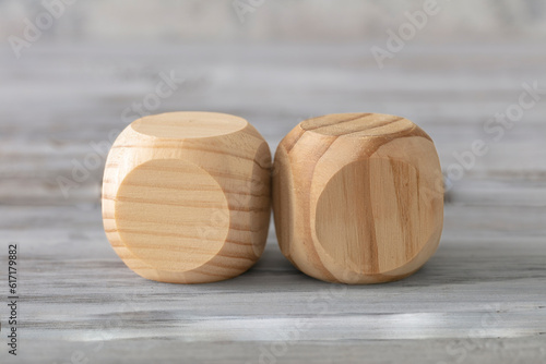  Two abstract geometric wooden dice isolate on white rustic surface. Antagonism concept.