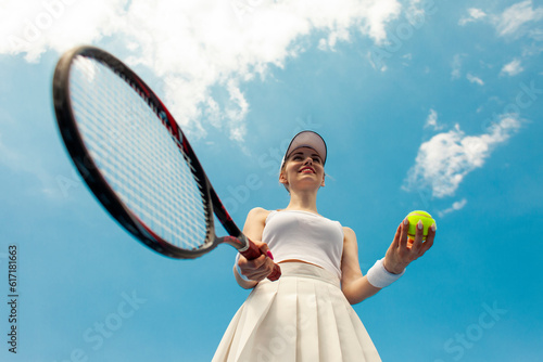 girl tennis player in white uniform holds racket and ball on the tennis court, woman athlete plays tennis © Богдан Маліцький