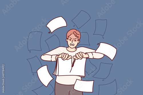 Angry man rips up documents after experiencing burst of aggression due to bureaucracy and stress of doing paperwork. Businessman throwing up documents with bad financial statements.