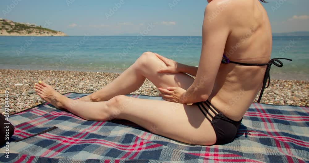 Woman apply sun protection cream on her body, medium shot Woman apply sun protection cream on her body, medium shot