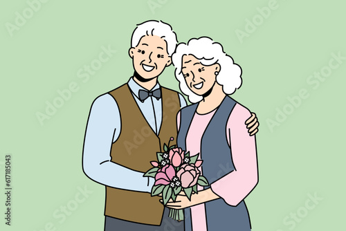 Elderly couple in love smiles rejoicing at happy family life, poses for picture on eve of golden wedding. Elderly family of man and woman hugging each other, looking at screen and laughing