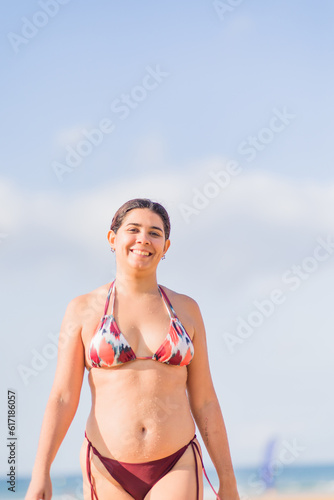 Summer holidays relax and wellbeing. Bikini body positivity Hispanic mid woman at beach. Asturias