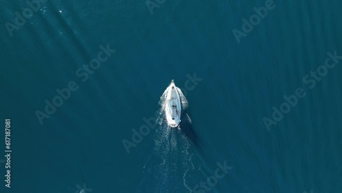 An aerial view of the sail yacht on the blue sea. Transparent clear water in the sea. Summer vacations and travels on a sailing yacht. Summer relaxation.