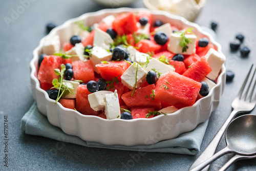 Summer salad with watermelon, feta cheese and blueberry on a gray background. Vegan, European food.