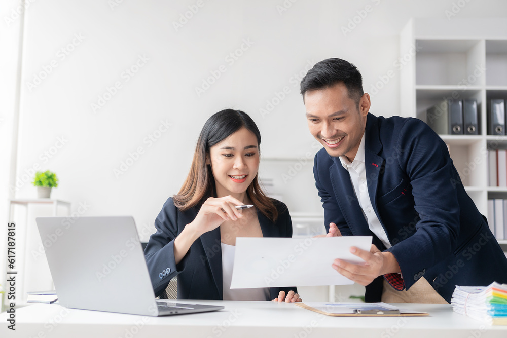 Smart and professional male manager working with his female assistant. check financial reports Analyze financial data with graph papers and laptop with desk. Smart and professional male manager working with his female assistant. check financial reports Analyze financial data with graph papers and laptop with desk.