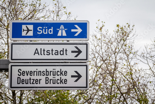 Fotografie, Obraz Selective blur on german roadsign in Cologne, Germany, directing to autobahn motorway heading south (Sud in German) & local road to Cologne districts of Severinsbrucke, Altstadt & Deutzer Brucke