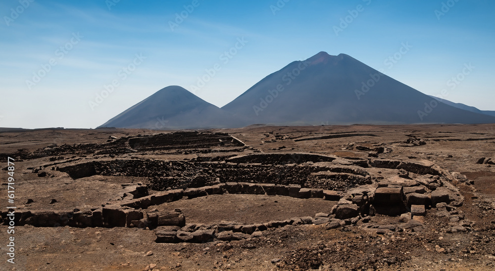 ancient archeology of stone houses with a volcano in the background in high resolution and sharpness in Latin America