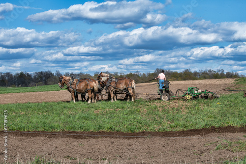 Young farmer prepares field in springtime for planting.