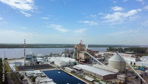 Drone flight elevation over pulp and paper mill on river coast photo