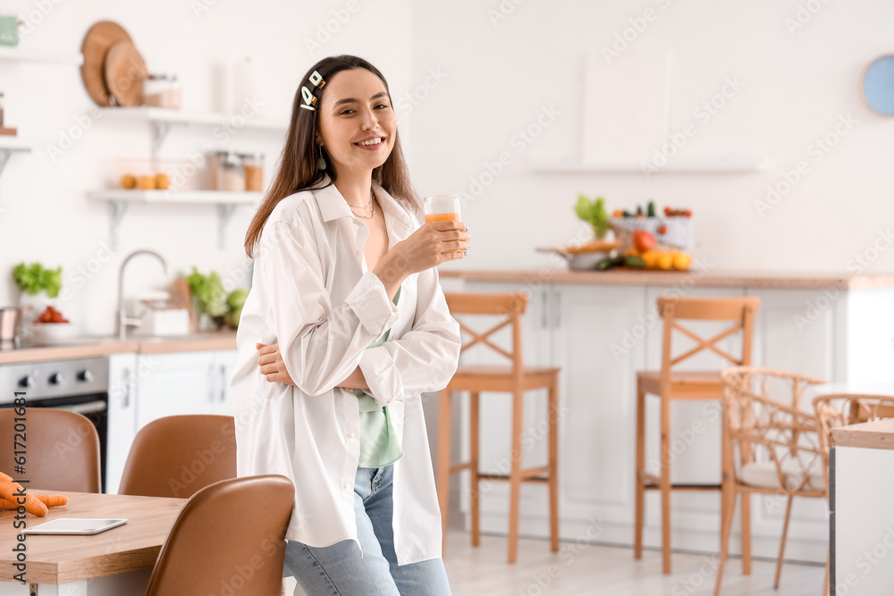 Young woman with glass of vegetable juice in kitchen Young woman with glass of vegetable juice in kitchen