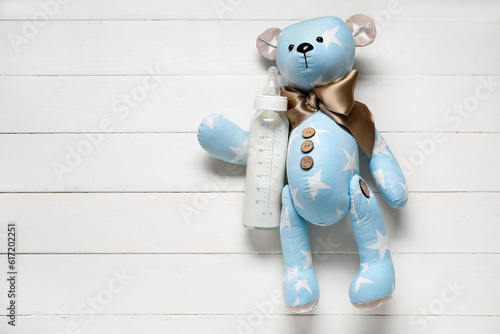 Teddy bear with bottle of m...