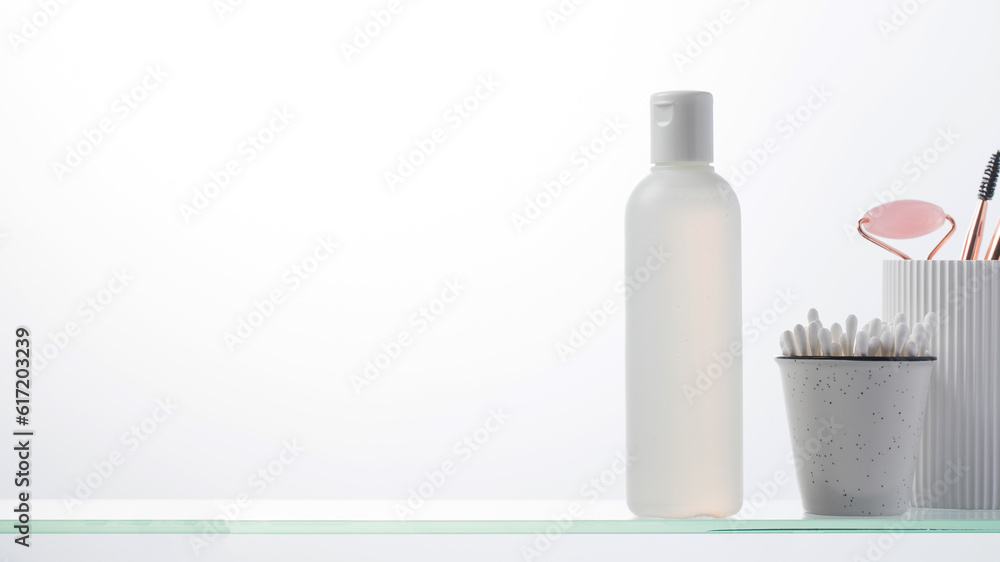 A bottle with a natural cosmetic product on a glass shelf. Copy space A bottle with a natural cosmetic product on a glass shelf. Copy space